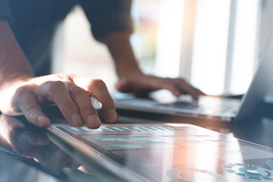 The Peterman Process - Businessman Analyzing Risk Using Tablet and Laptop in the Office